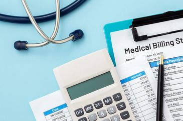 Medical billing statement with calculator and stethoscope.