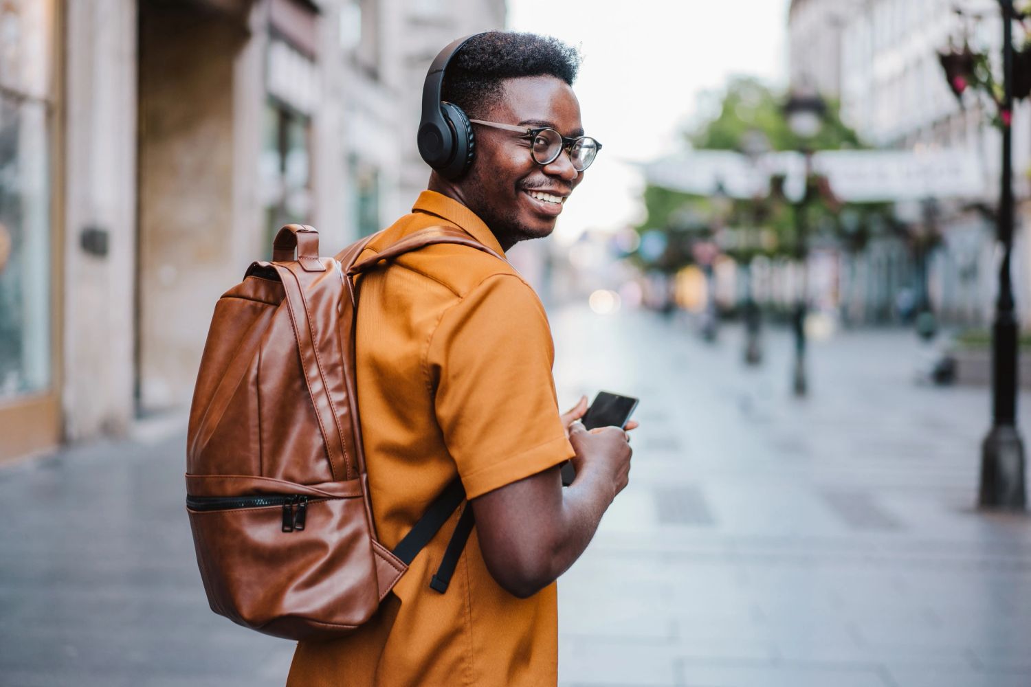 Man with brown leather backpack for travel.