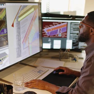 Man working on architectural designs on computer screens.