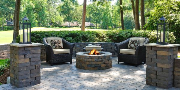Cozy outdoor seating area with a stone fire pit and lanterns.