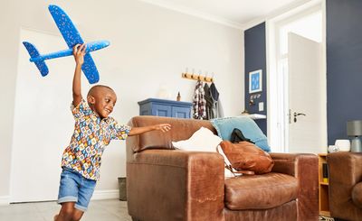 young child transitioning from one activity to the next flying a toy airplane