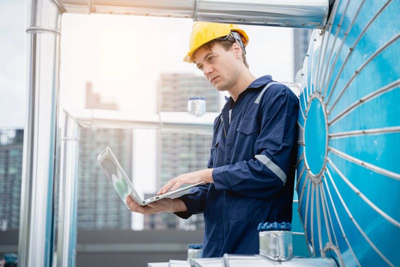 A team of engineers is checking the air conditioning cooling system of a major building or industrial facility.