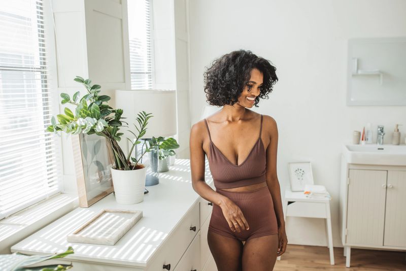 Happy relaxed millennial African girl in bathroom enjoying her morning.
