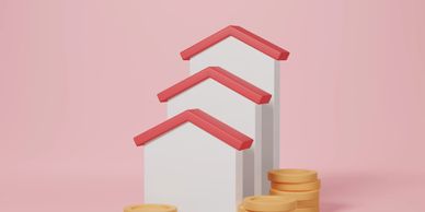 3D houses with red roofs increasing in size next to stacks of coins.