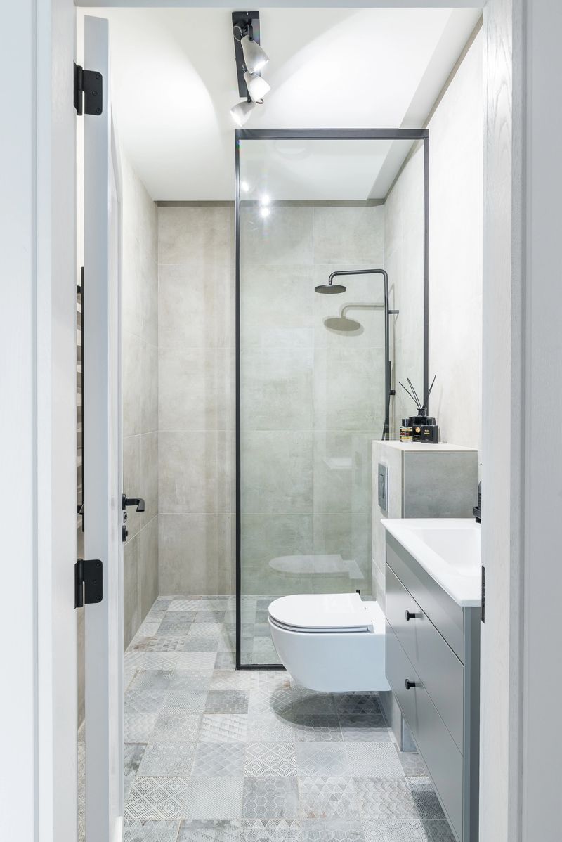 Illuminated bright and modern bathroom through open door.