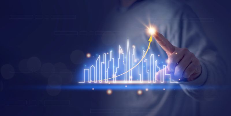 The concept of real estate business, the target of business growth, a businessman's hand pointing to business goal on virtual screen. High-rise building, real estate economic growth analysis.