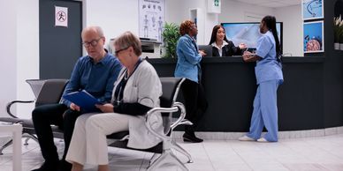 People waiting and interacting in a modern medical clinic's reception area.