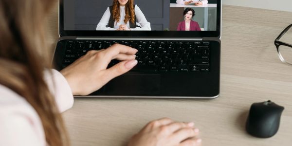 Person in video call on laptop.