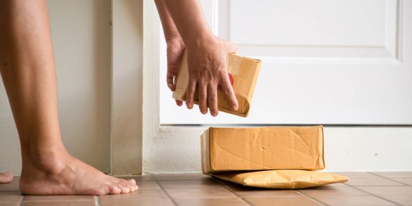 Person picking up parcels from the doorstep.