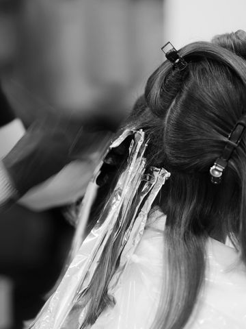 Hair coloring process with foil wraps in a salon.