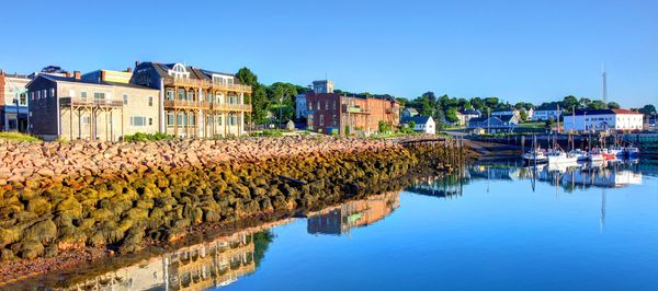 Coastal town with clear blue sky and calm reflective water.