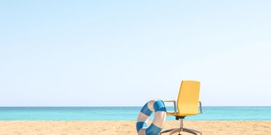 Office chair and lifebuoy on a beach shore.