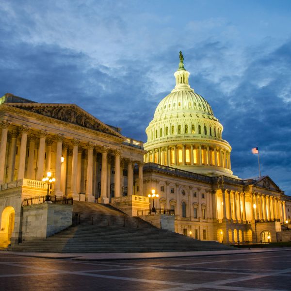 The illuminated United States Capitol building at dusk.