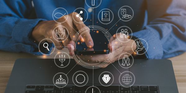 Person using phone with digital religious icons overlay.