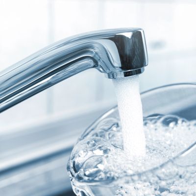 Water flowing from a faucet into a glass.