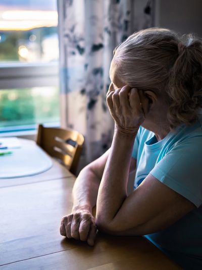 A woman sitting at a table looking out the window.