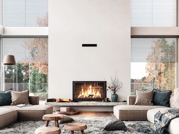 Modern living room with a cozy fireplace and large windows.