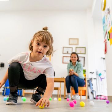 Young girl playing with colorful balls indoors.