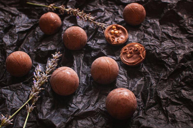 chocolate round candies on dark crumpled craft paper with lavender flowers