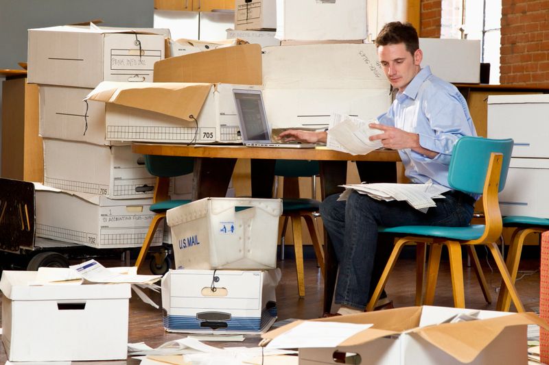 Man in an office over flowing with paperwork