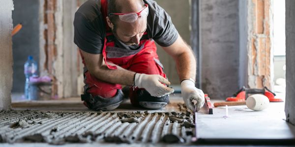 Worker laying tiles on the floor.