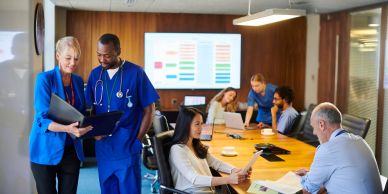 Healthcare professionals and office workers collaborating in a meeting room.