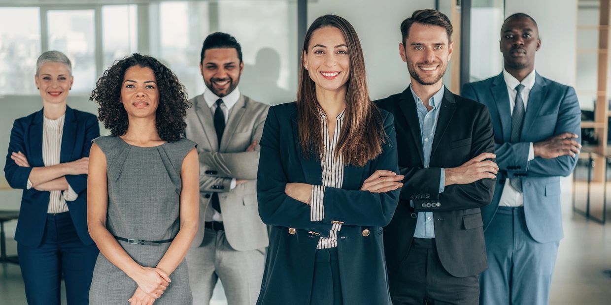 Confident diverse professionals posing together in an office.