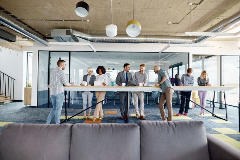 Large group of happy business colleagues cooperating while working on different things in a modern office.