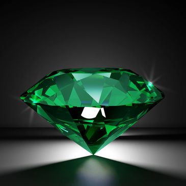 A sparkling green emerald gemstone on a dark background.