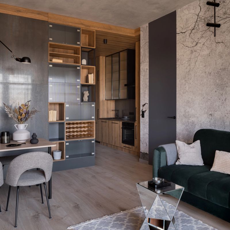 Small and modern apartment interior with kitchen in corridor open to living room with dining table