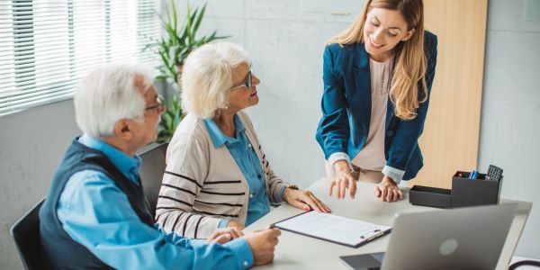 Senior couple discussing paperwork with a female advisor.
