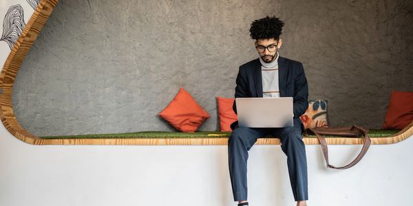 Man working on laptop in a cozy, modern workspace.