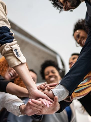 Group of people joining hands in solidarity.