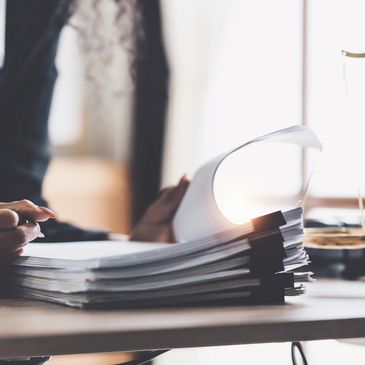 Person reviewing legal documents with gavel and scales on desk.