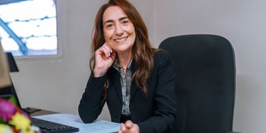 Smiling businesswoman sitting at desk in office.