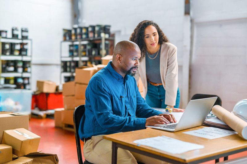Logistics, ecommerce and business people working on laptop delivery, shipping or online shopping orders. Cargo, supply chain and checklist with employees in storage, package factory warehouse
