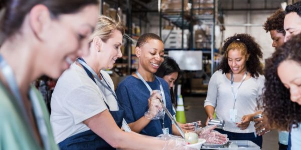 Volunteers preparing food together in a community kitchen.