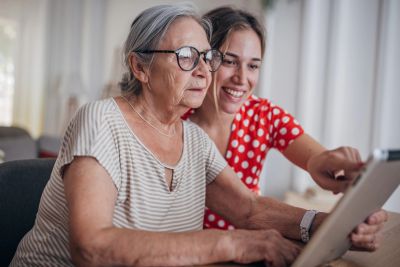 Older woman and young woman using a tablet together.