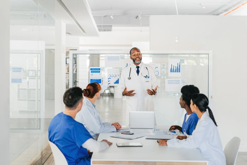 Presentation, training and coaching with a doctor and his team in a medical meeting for learning and development. Healthcare, research and innovation with a group of health professionals at work