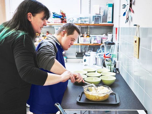 Two people cooking together in a kitchen.