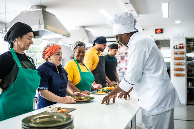 Chef analyzing food prepared by students during cooking class