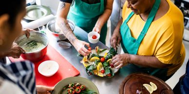 People preparing and plating food in a kitchen.