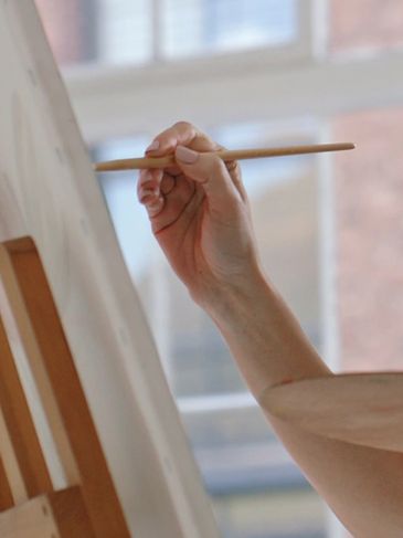 Close up of hand painting a canvas in an art studio