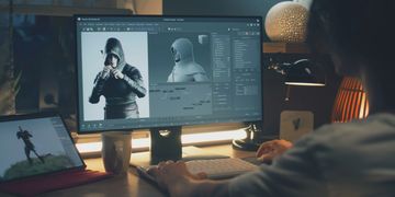 Person working on 3D character modeling using software on a computer.