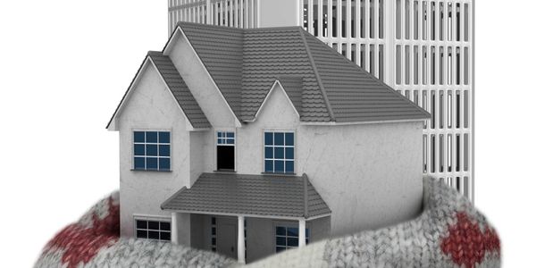 House wrapped in a sweater with solar panels and an air conditioning unit.