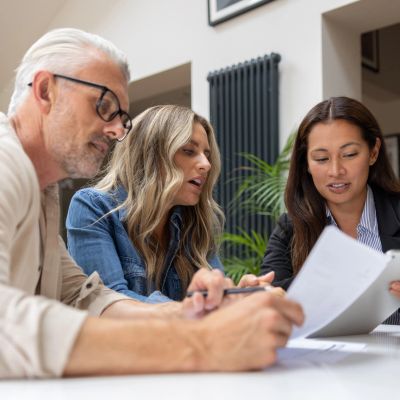 Three professionals discussing documents at a table.
