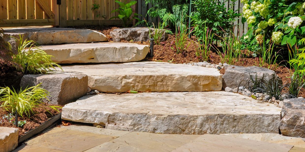 Natural stone steps with lush greenery and wooden fences.