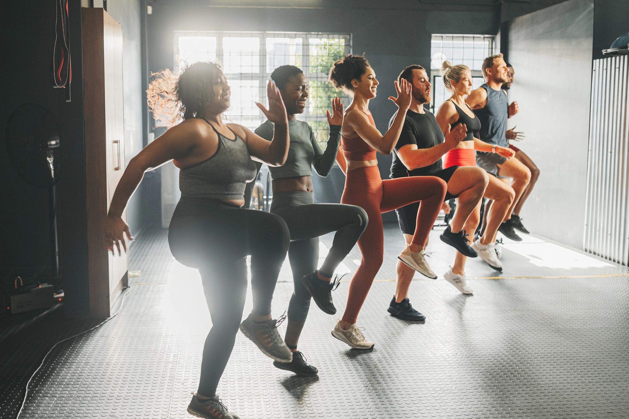A group fitness class energizing with high knee exercises indoors.