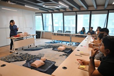 Instructor performing CPR training for a group.