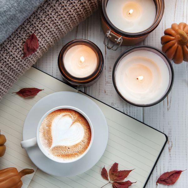 Cozy autumn setup with latte and candles.